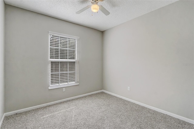 carpeted empty room featuring ceiling fan, a textured ceiling, and baseboards