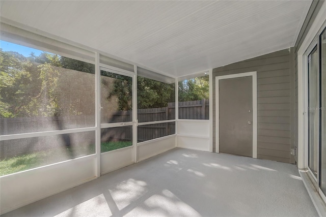 unfurnished sunroom featuring vaulted ceiling