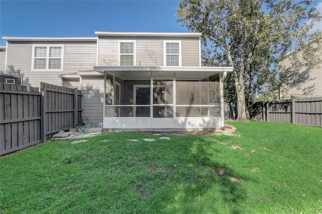 back of house with a sunroom, a fenced backyard, and a lawn