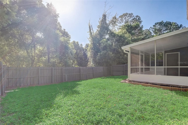 view of yard with a sunroom and a fenced backyard