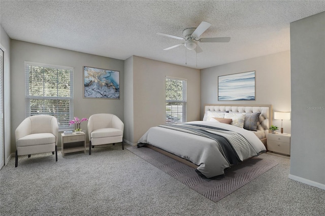 carpeted bedroom featuring ceiling fan, a textured ceiling, and baseboards