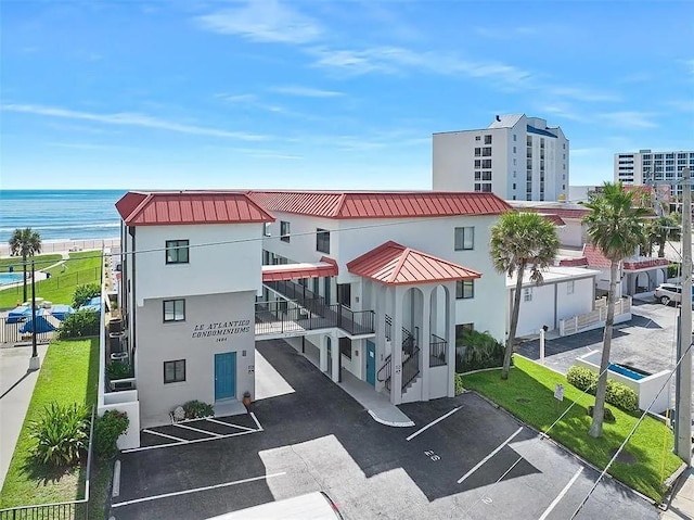 view of property with uncovered parking and a water view