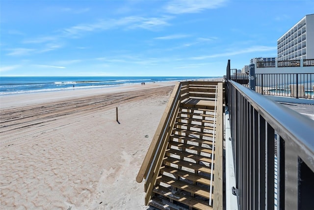 view of property's community featuring a water view and a beach view