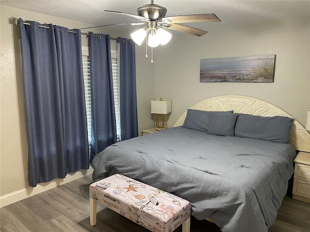 bedroom with a textured ceiling, light wood finished floors, a ceiling fan, and baseboards