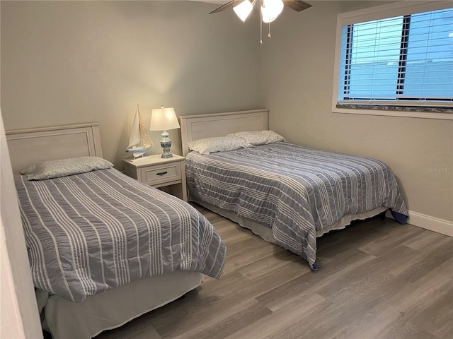 bedroom with baseboards and wood finished floors