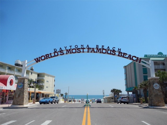 view of street featuring a water view, sidewalks, and curbs