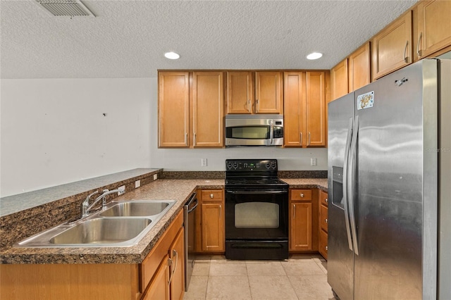 kitchen featuring light tile patterned flooring, sink, stainless steel appliances, and a textured ceiling