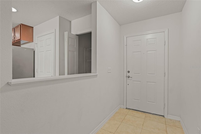 doorway featuring a textured ceiling and light tile patterned floors