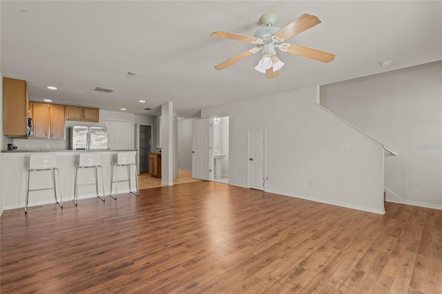 unfurnished living room featuring ceiling fan and light hardwood / wood-style floors