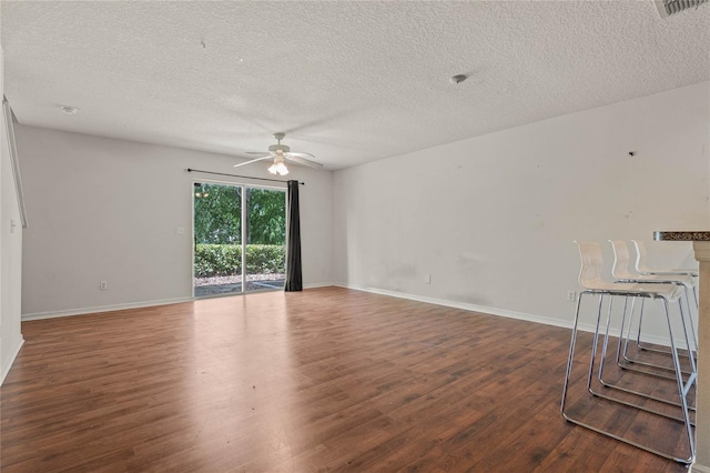 empty room featuring a textured ceiling, ceiling fan, and wood-type flooring