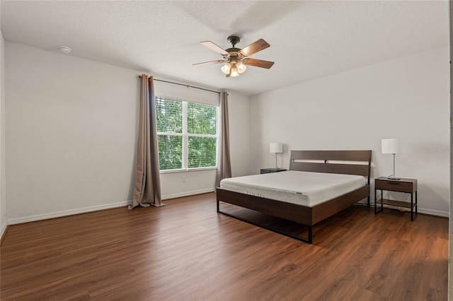 bedroom featuring ceiling fan, a textured ceiling, and dark hardwood / wood-style flooring