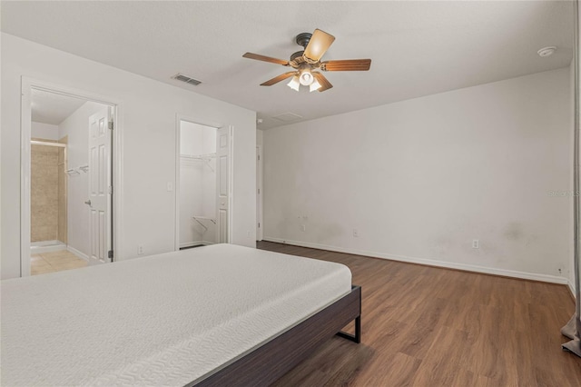 bedroom with ceiling fan, a spacious closet, light hardwood / wood-style flooring, a closet, and ensuite bathroom