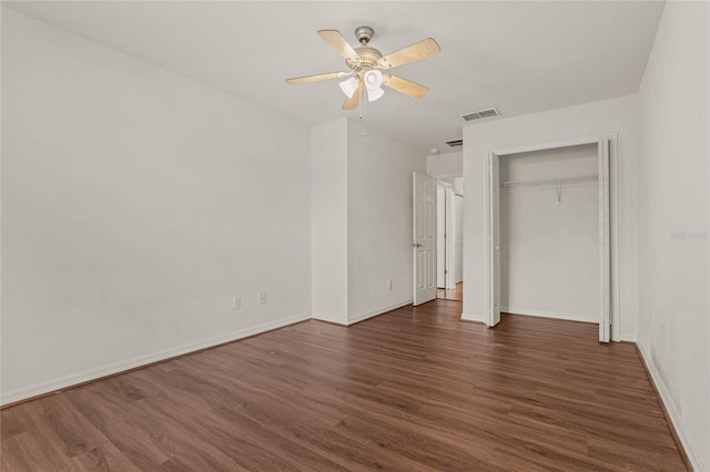 unfurnished bedroom with ceiling fan, dark wood-type flooring, and a closet