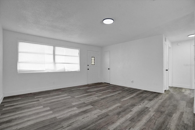 spare room with a wealth of natural light, hardwood / wood-style flooring, and a textured ceiling