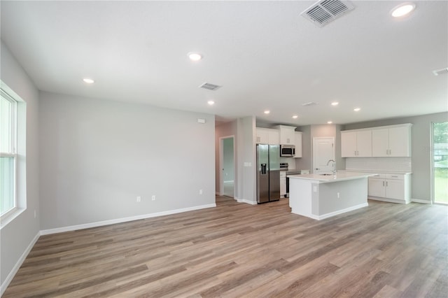 kitchen featuring light countertops, light wood-style flooring, visible vents, stainless steel appliances, and open floor plan