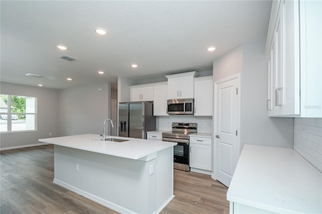 kitchen featuring a sink, white cabinetry, light wood-style flooring, and appliances with stainless steel finishes