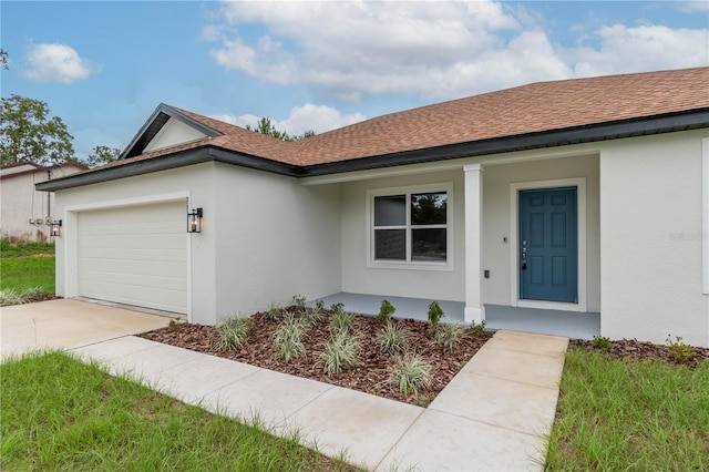 view of front facade with a garage, concrete driveway, and stucco siding