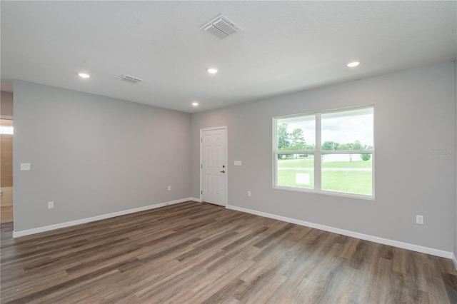 spare room featuring baseboards, visible vents, recessed lighting, and wood finished floors