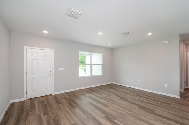 spare room with baseboards, visible vents, wood finished floors, and recessed lighting
