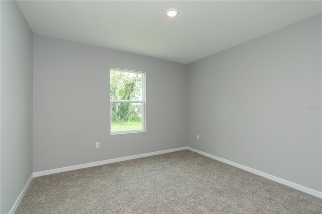 empty room with baseboards and carpet