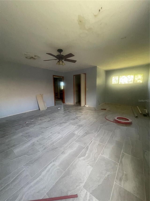 unfurnished living room with light tile patterned floors and ceiling fan