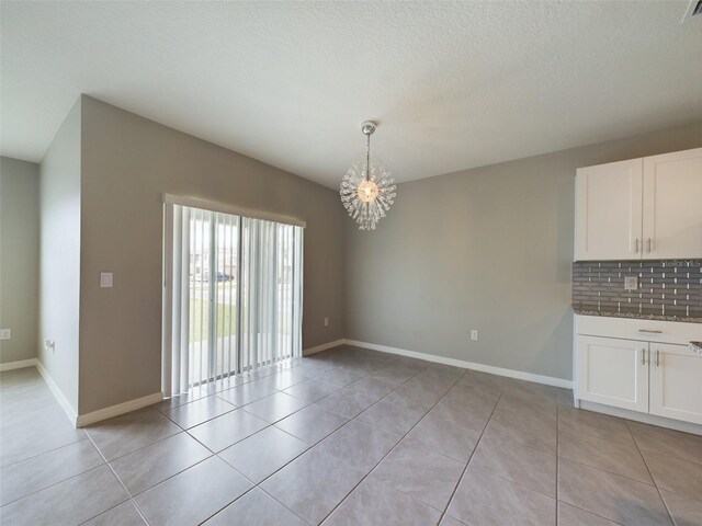 1502 Jadewood Way, Kissimmee, FL 34744 - unfurnished dining area with light tile patterned floors, an inviting chandelier, and baseboards