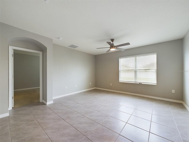 1502 Jadewood Way, Kissimmee, FL 34744 - unfurnished room with a ceiling fan, arched walkways, visible vents, and light tile patterned floors