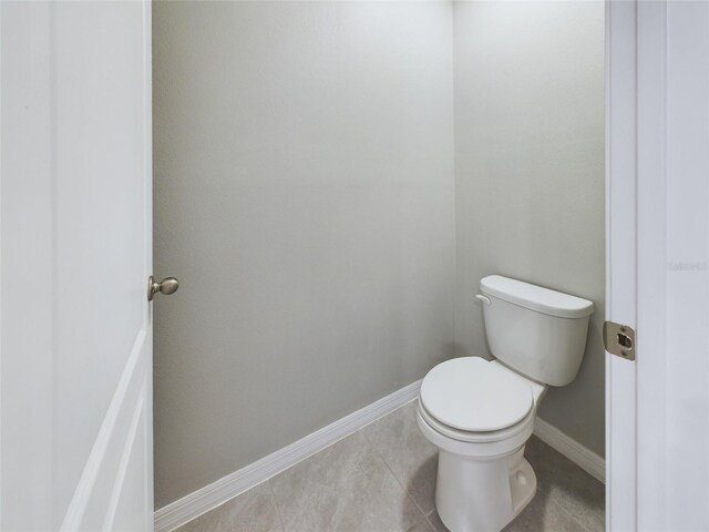1502 Jadewood Way, Kissimmee, FL 34744 - bathroom with baseboards, toilet, and tile patterned floors