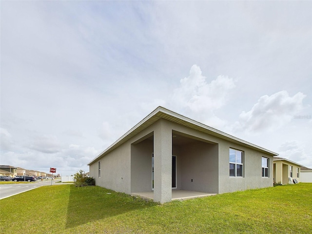 1502 Jadewood Way, Kissimmee, FL 34744 - rear view of property featuring a patio area, a lawn, and stucco siding