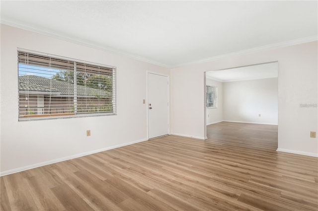 empty room with hardwood / wood-style flooring and ornamental molding