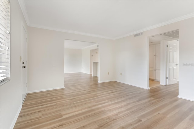 empty room featuring ornamental molding and light wood-type flooring