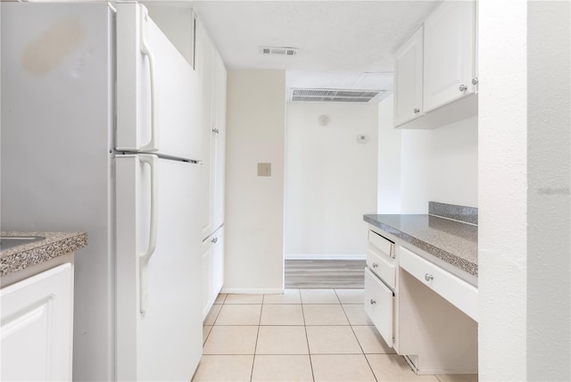 kitchen with light wood-type flooring, white cabinetry, and white fridge