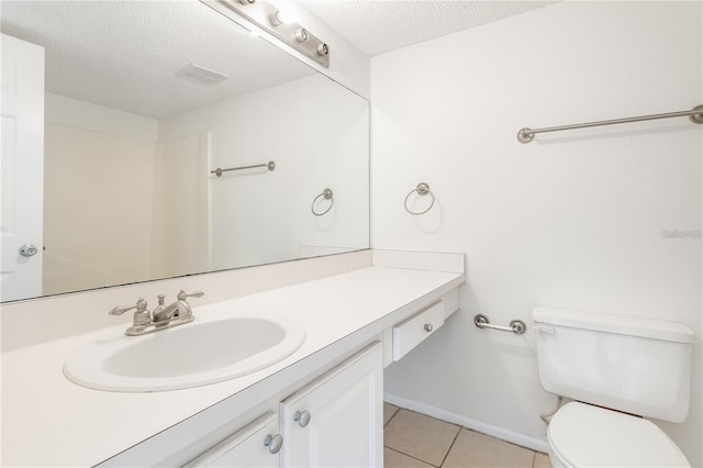 bathroom with tile patterned floors, toilet, a textured ceiling, and vanity