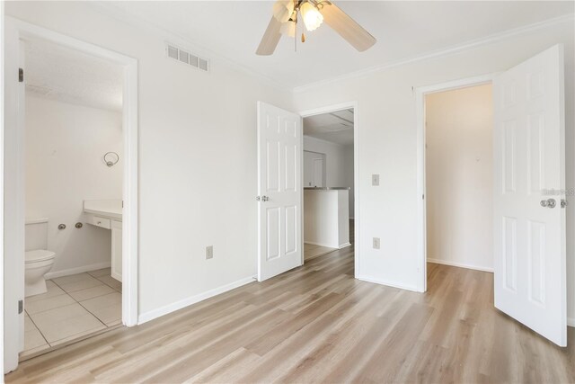 unfurnished bedroom with ceiling fan, light wood-type flooring, a closet, and ensuite bath