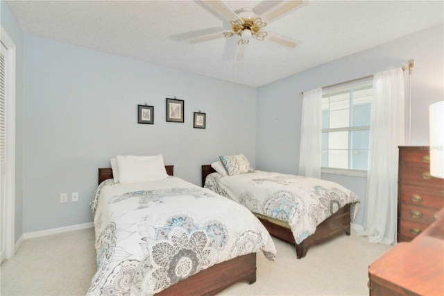 carpeted bedroom with ceiling fan and a textured ceiling