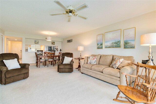 living room featuring carpet, a textured ceiling, and ceiling fan