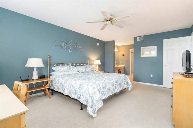 bedroom featuring ceiling fan, light colored carpet, and ensuite bathroom