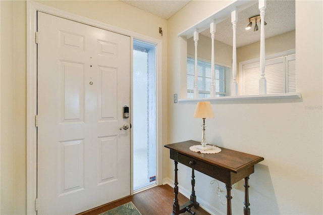 entrance foyer featuring a textured ceiling and dark hardwood / wood-style floors