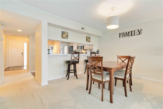 carpeted dining space featuring crown molding