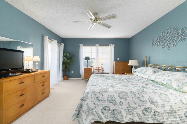 carpeted bedroom with ceiling fan and a textured ceiling