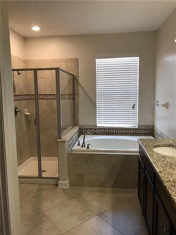 bathroom with independent shower and bath, vanity, and tile patterned floors