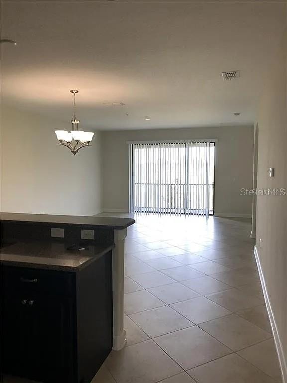 interior space featuring decorative light fixtures, an inviting chandelier, and light tile patterned floors