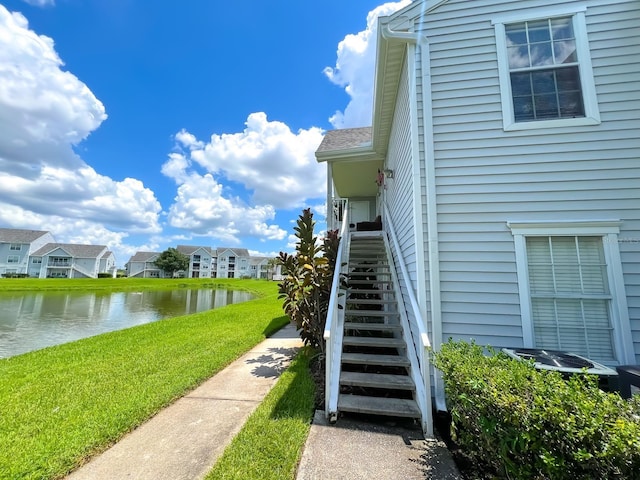 exterior space featuring a lawn and a water view