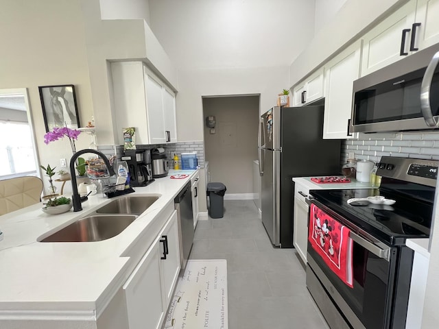 kitchen featuring light tile patterned floors, appliances with stainless steel finishes, sink, and tasteful backsplash