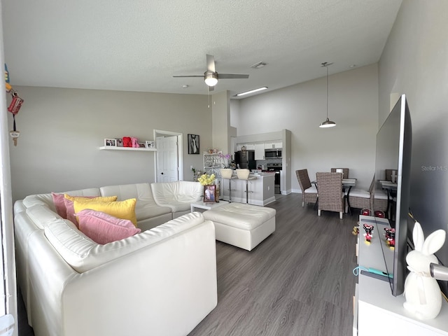 living room featuring ceiling fan, high vaulted ceiling, a textured ceiling, and hardwood / wood-style floors