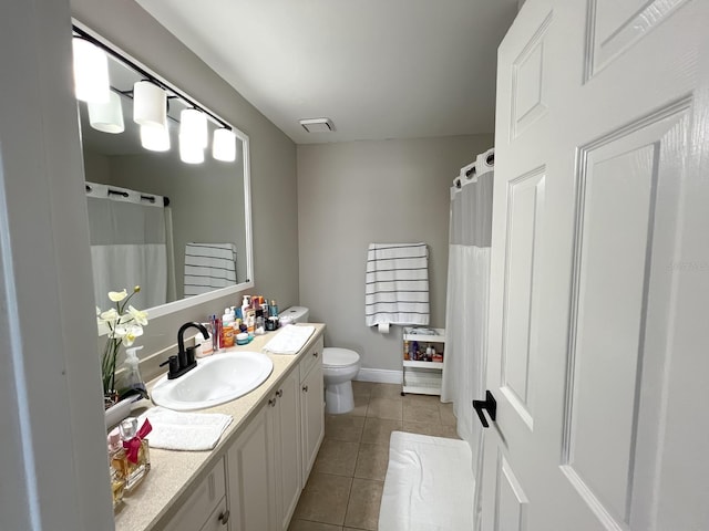 bathroom with toilet, vanity, and tile patterned floors