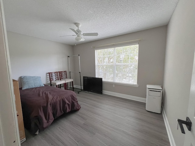 bedroom featuring hardwood / wood-style flooring, a textured ceiling, and ceiling fan