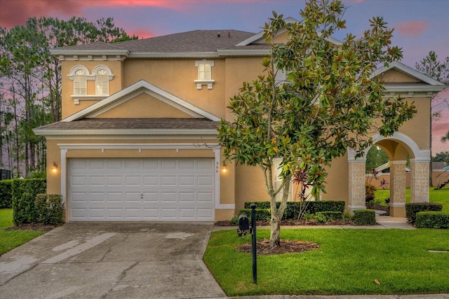 view of front of home featuring a garage and a lawn