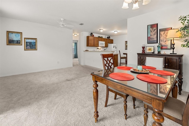 dining area with light colored carpet and ceiling fan