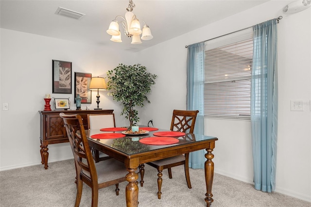 dining room with an inviting chandelier and light carpet